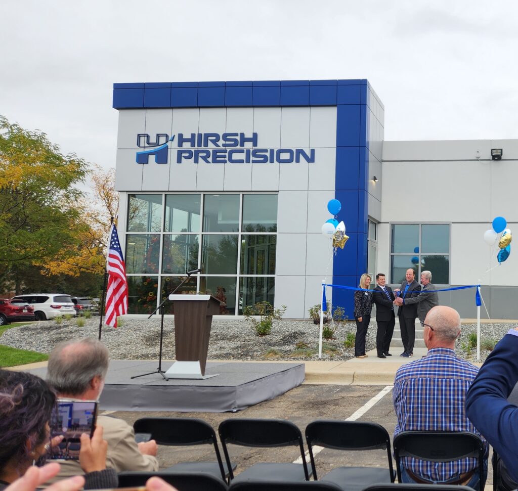 Commercial building exterior during ribbon cutting ceremony with officials and guests