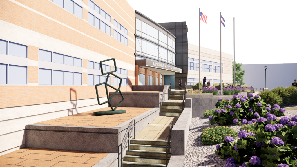 Modern exterior entrance of the Longmont Safety and Justice Center with landscaped pathways, flags, and contemporary architecture