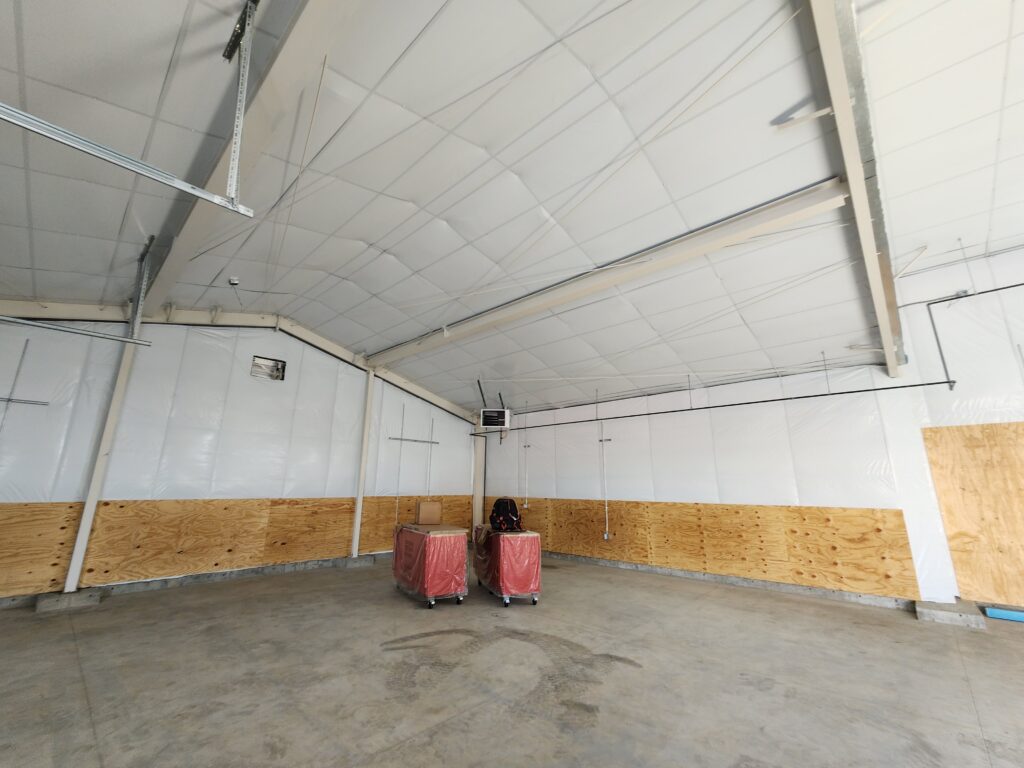 Interior view of a modern agricultural building with open workspace, high ceilings, and functional interior design by PEH Architects