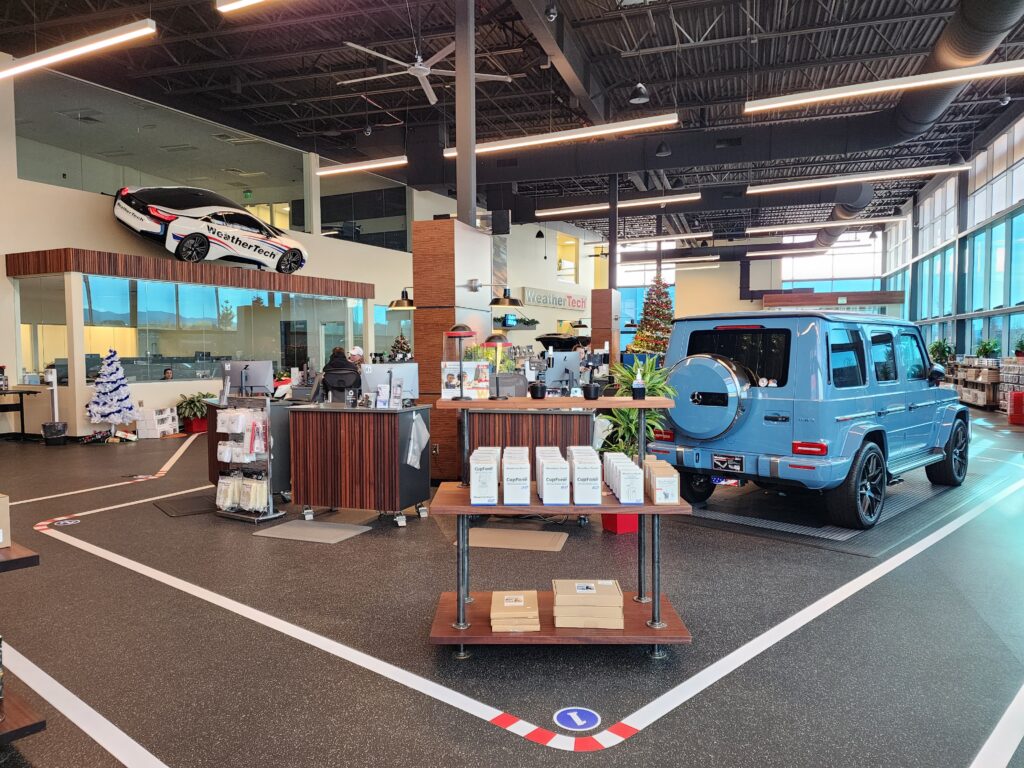 Modern automotive showroom display area with luxury vehicles, product displays, and contemporary interior architecture