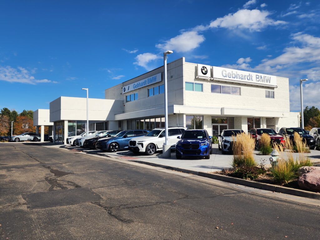 Modern BMW dealership building exterior with vehicle display area, glass windows, and contemporary commercial architecture