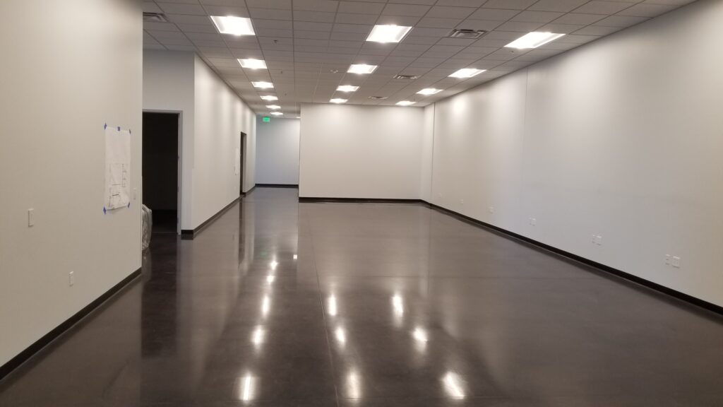 Modern commercial interior open space with polished flooring, clean walls, ceiling lighting, and flexible workspace design by PEH Architects