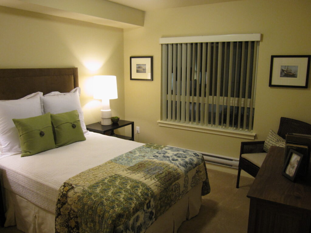 Contemporary bedroom interior with modern bed, warm lighting, window blinds, and elegant residential design details