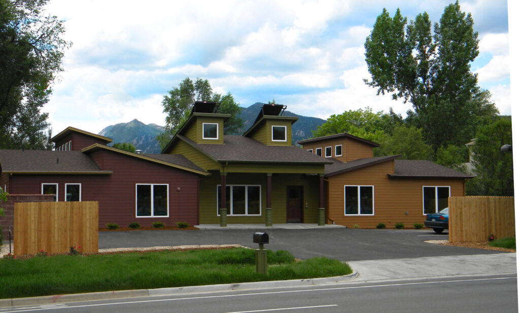 Contemporary house exterior design with modern architecture, large windows, covered entrance, and mountain landscape background