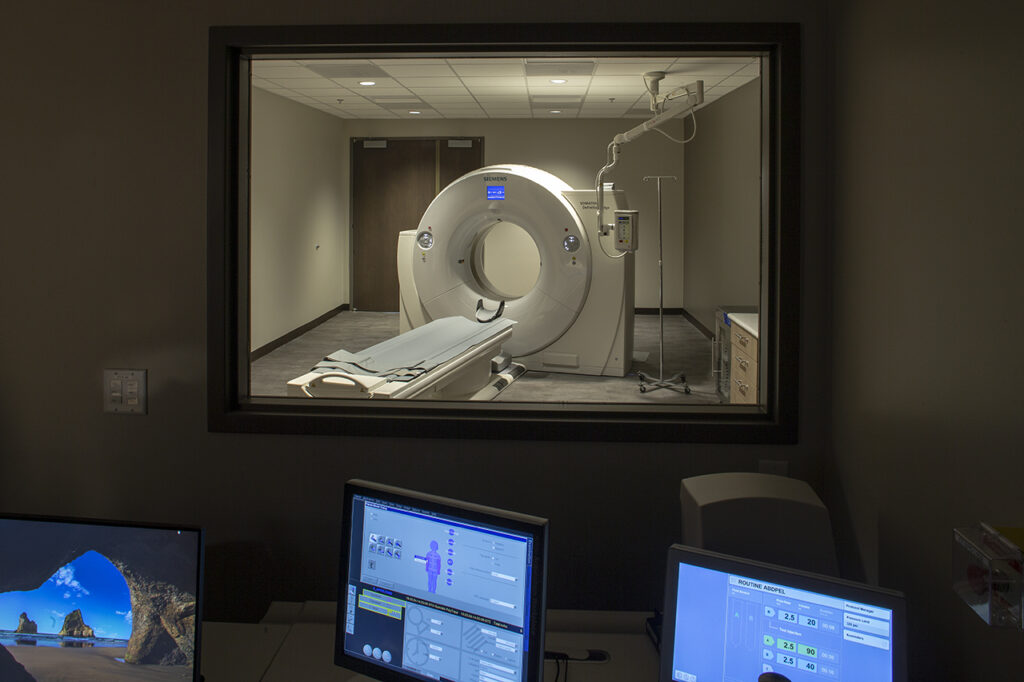 CT scan control room with medical monitoring equipment and imaging suite interior design