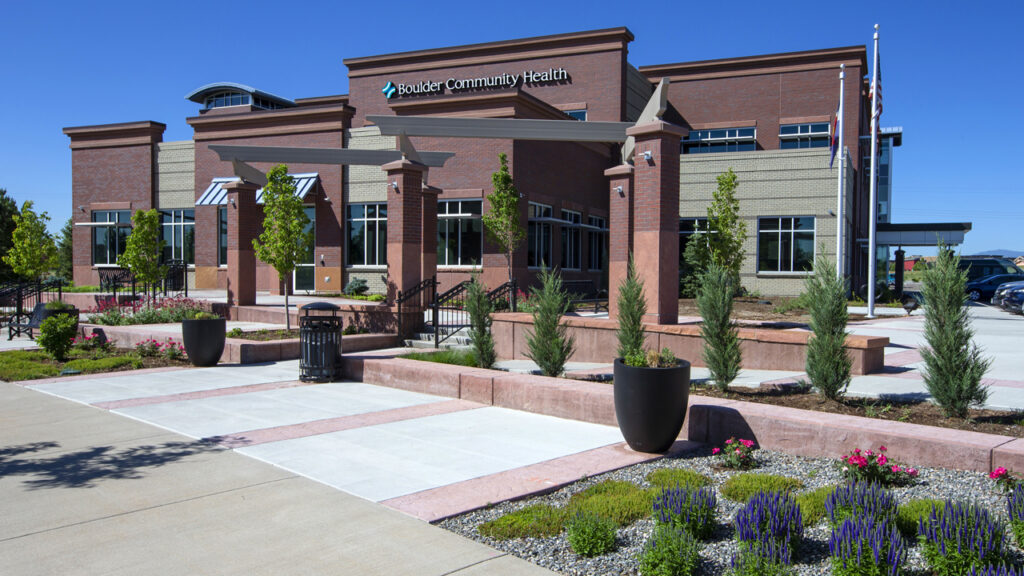 Modern healthcare facility exterior with brick building design, landscaped entrance, and contemporary medical architecture