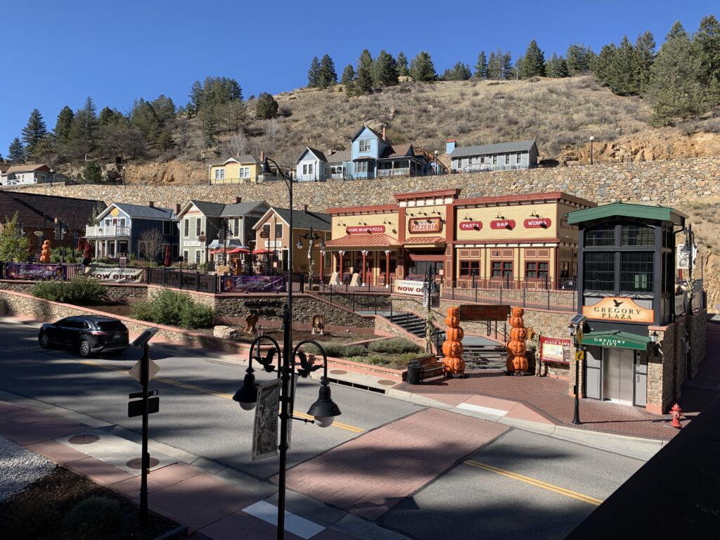 Historic commercial plaza with restaurants, storefronts, pedestrian walkways, and mountain town architecture