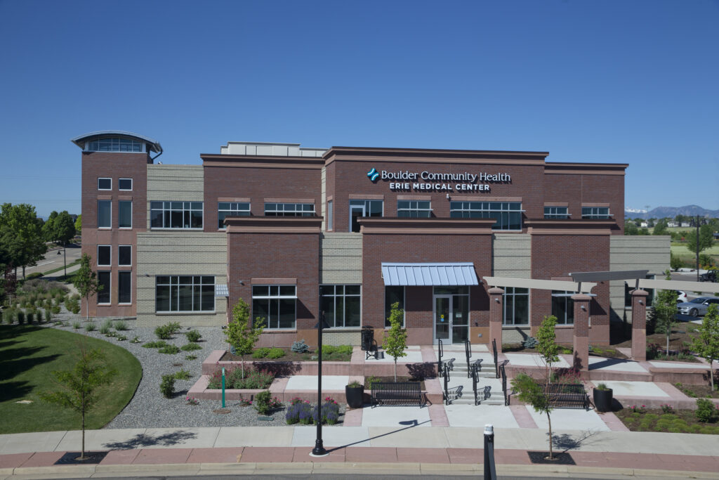 Modern medical center exterior with brick façade, glass windows, landscaped entrance, and healthcare architecture design