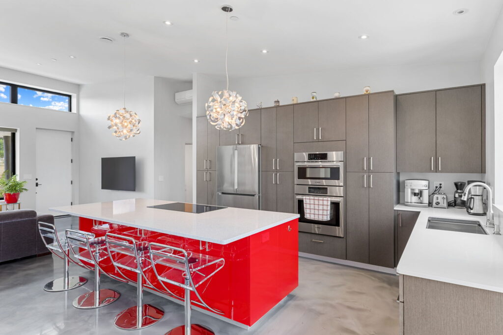 PEH Architects modern kitchen interior with contemporary cabinets and red island design