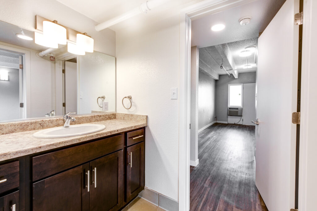 Modern bathroom vanity with wooden cabinets, countertop sink, mirror, and contemporary interior design