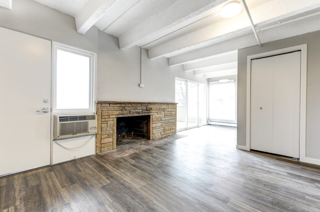Modern living room with stone fireplace, large windows, and contemporary interior design