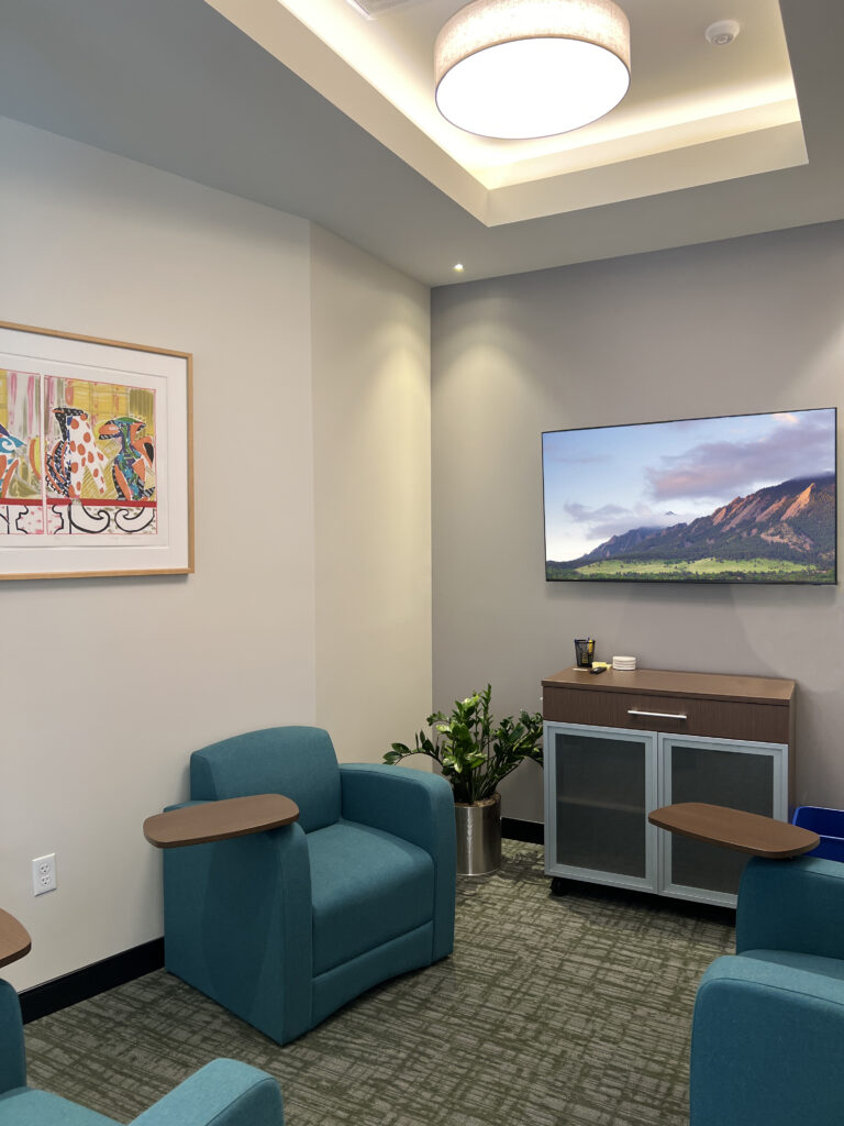 PEH Architects modern office waiting area with lounge seating, TV display, and contemporary interior design