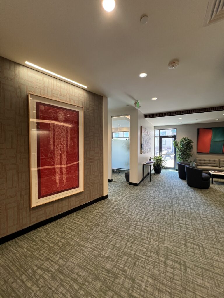PEH Architects modern office lobby with textured walls, artwork, lounge seating, and contemporary interior design