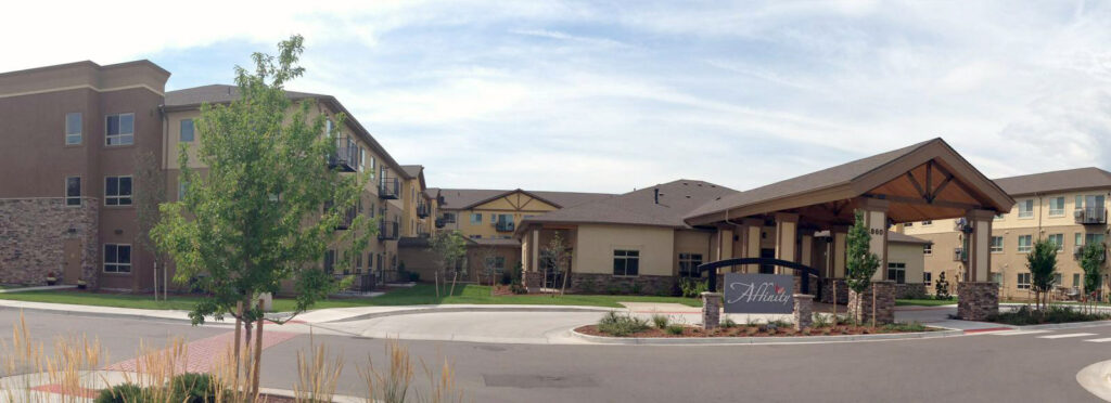 Multi-family residential building exterior with modern architecture, landscaped entrance, and community design features