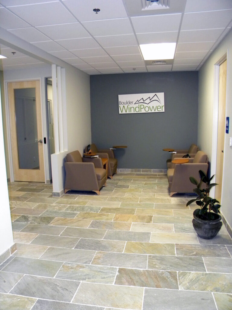 Modern office reception area with seating, branded wall signage, and contemporary interior design by PEH Architects