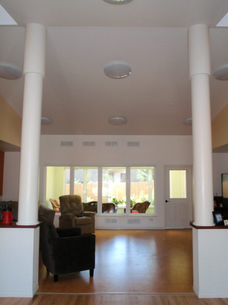 Open lounge interior design with modern columns, large windows, comfortable seating, and natural lighting
