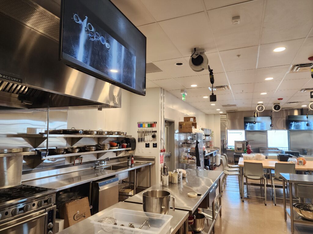 Professional culinary training lab with stainless steel cooking stations and kitchen equipment