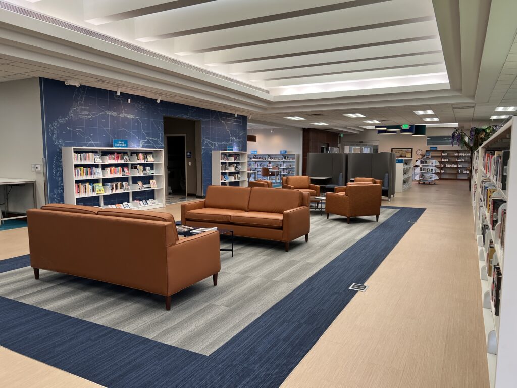 Spacious modern library interior with lounge sofas, bookshelves, study areas, and open reading space