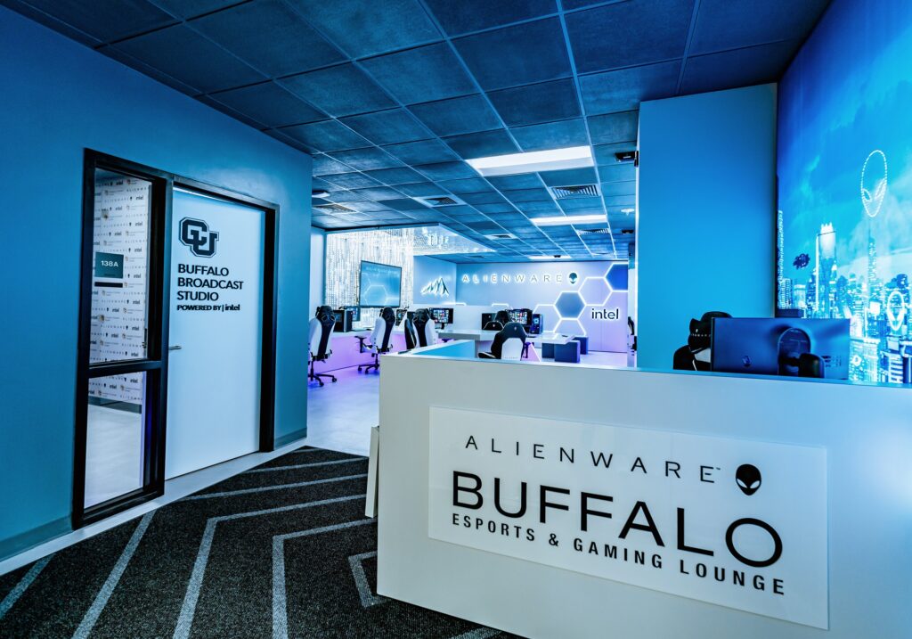 Alienware Buffalo esports gaming lounge interior with blue LED lighting, gaming computers, reception desk, and modern technology design