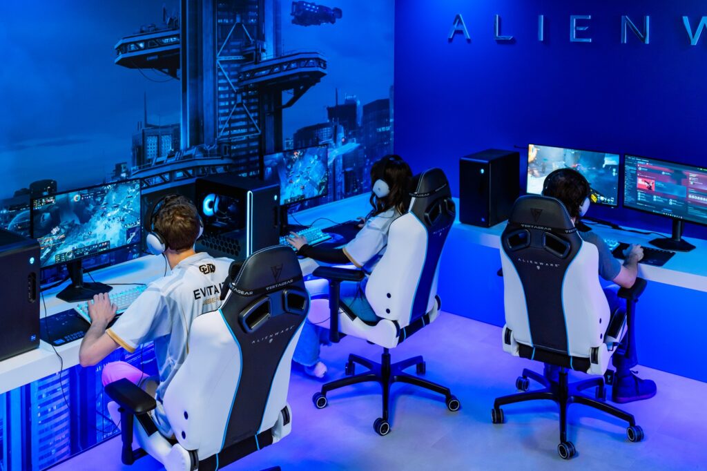 Alienware esports gaming room with players using gaming PCs, monitors, chairs, and blue LED lighting setup