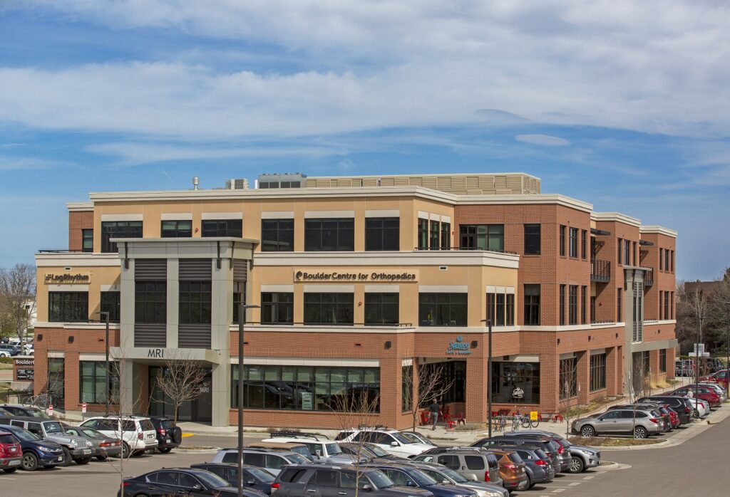 Boulder Centre for Orthopedics modern medical office building with brick exterior, glass windows, parking area, and healthcare facilities
