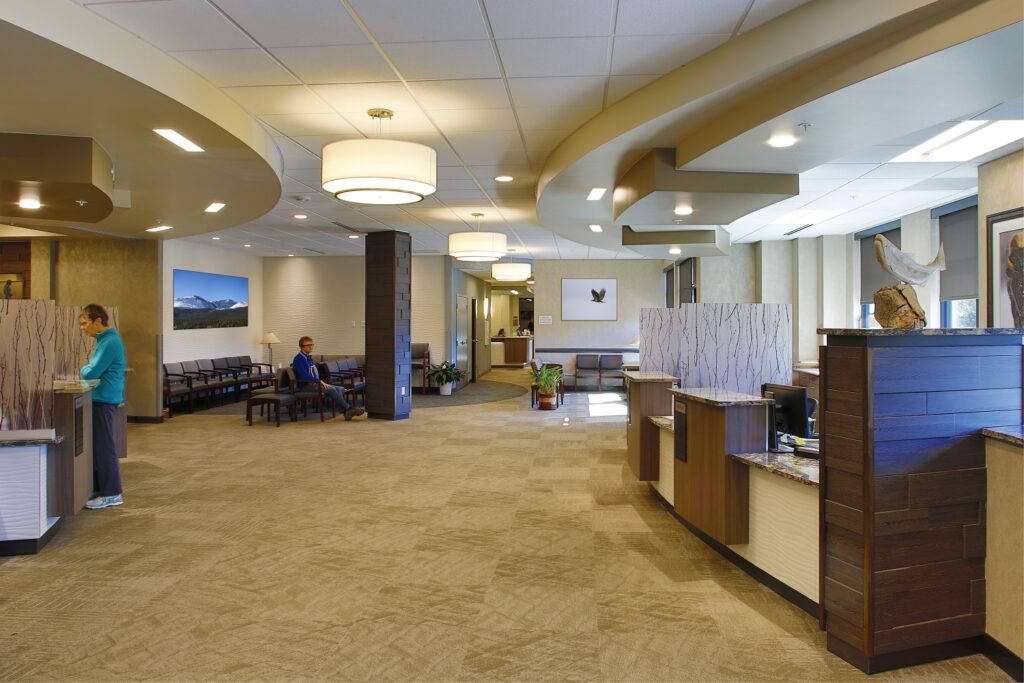 Modern healthcare clinic interior with reception desk, patient waiting area, seating, lighting, and contemporary medical office design