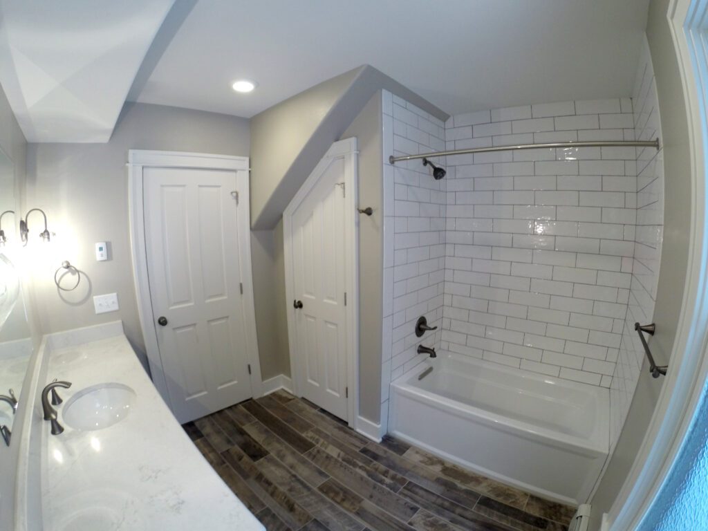 Modern bathroom remodel featuring white subway tile shower, bathtub, contemporary fixtures, and elegant interior design by PEH Architects in Boulder
