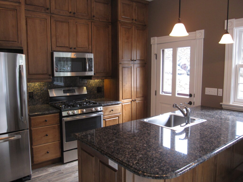 Modern kitchen renovation featuring custom wood cabinetry, granite countertops, stainless steel appliances, and contemporary design by PEH Architects in Boulder