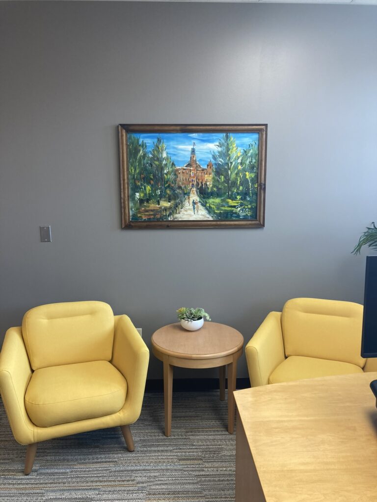 Modern Boulder office interior featuring yellow lounge chairs, wooden side table, wall artwork, and contemporary workspace design by PEH Architects