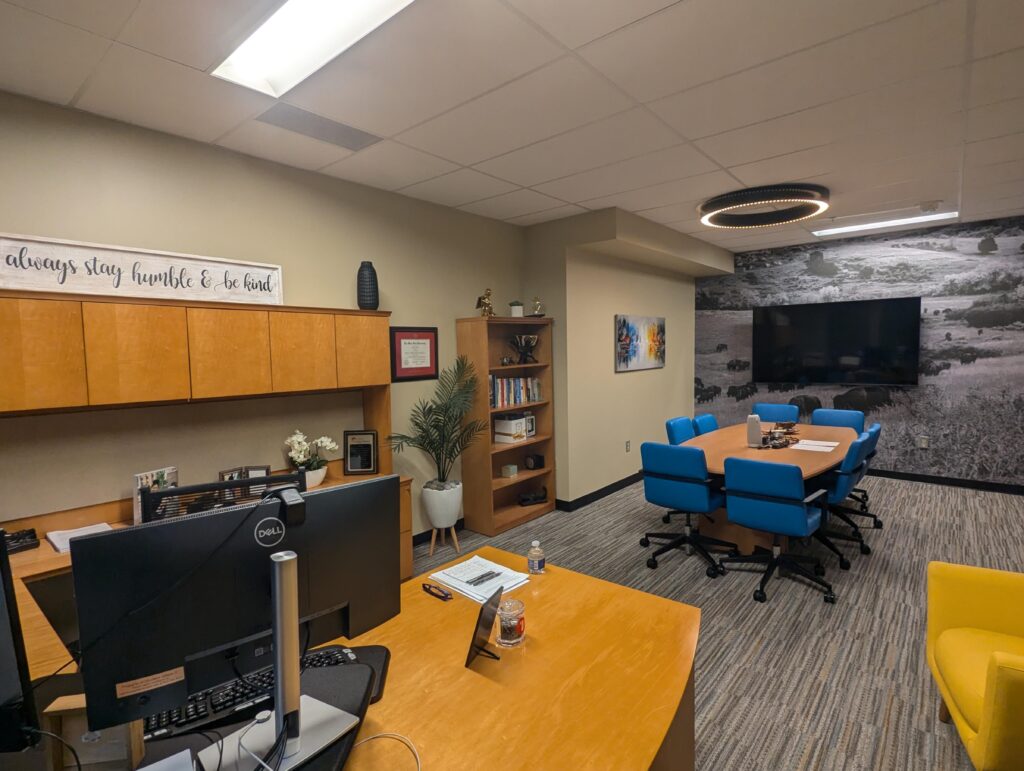 Modern Boulder office interior featuring conference table, blue chairs, workspace desks, wall artwork, and contemporary meeting room design by PEH Architects