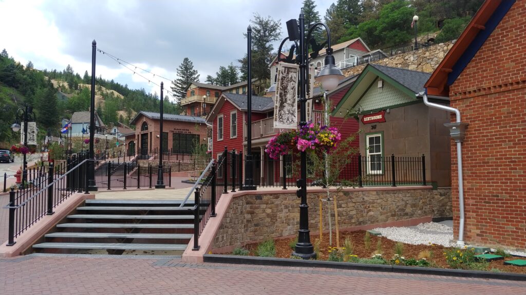 Historic district streetscape featuring restored buildings, landscaped walkways, decorative lighting, stone walls, and community outdoor spaces
