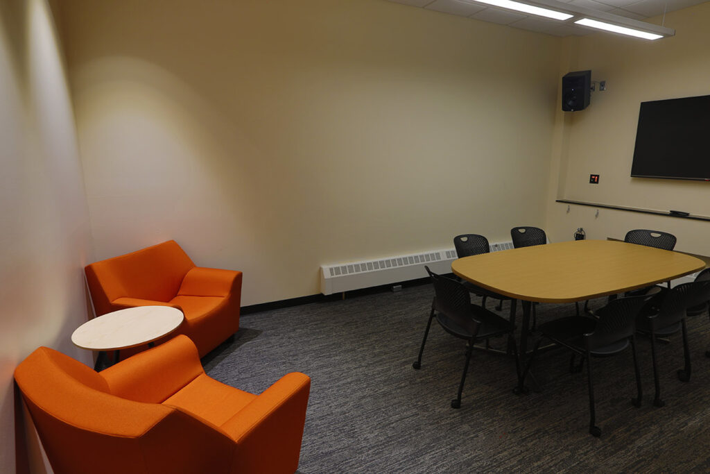 Modern meeting room interior featuring conference table, collaborative seating, presentation screen, and contemporary office design by PEH Architects