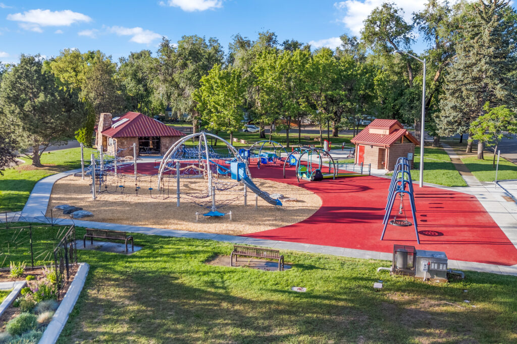 Neighborhood park with modern playground equipment, accessible play areas, swings, walking paths, and landscaped green space designed by PEH Architects in Boulder.